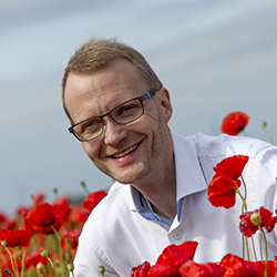 Kenneth Jensen i en mark af røde valmuer. Foto: Preben Gøttsche.